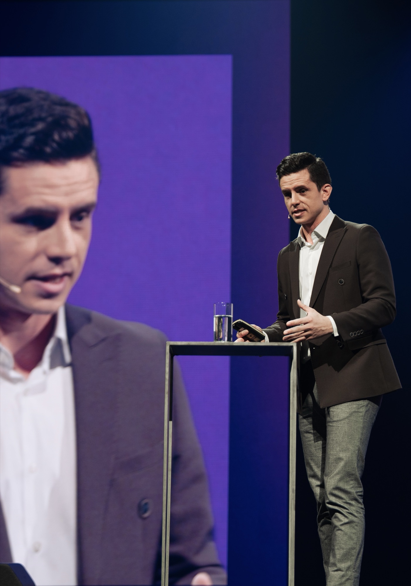 Nimrod on stage with giant screen behind